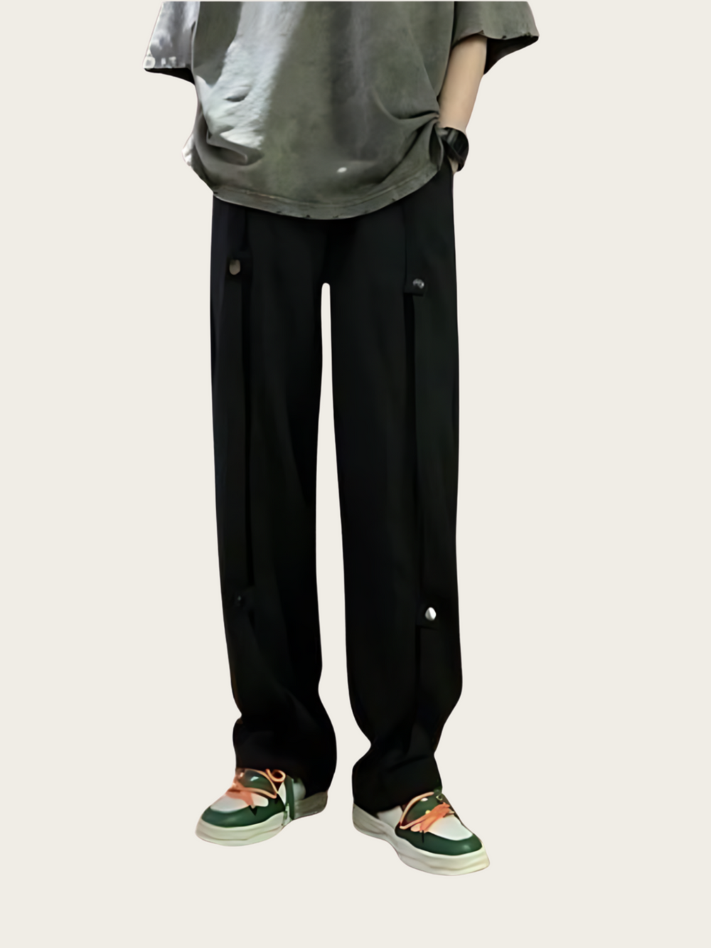 Person wearing black pants and green sneakers on a light gray background