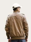 Person wearing a brown jacket and white cap from behind on a plain background