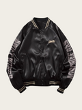 Black satin bomber jacket with text on sleeves against a beige background