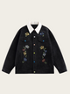 Black jacket with floral embroidery on a beige background