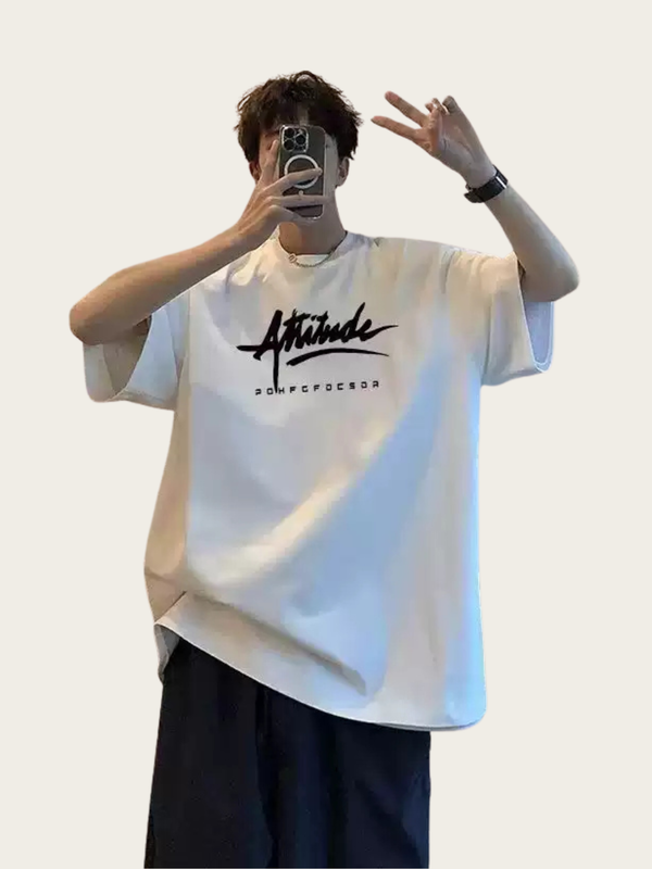 Person wearing a white t-shirt with a logo and text, taking a mirror selfie.