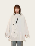 Person wearing a white oversized jacket with a front pocket on a white background
