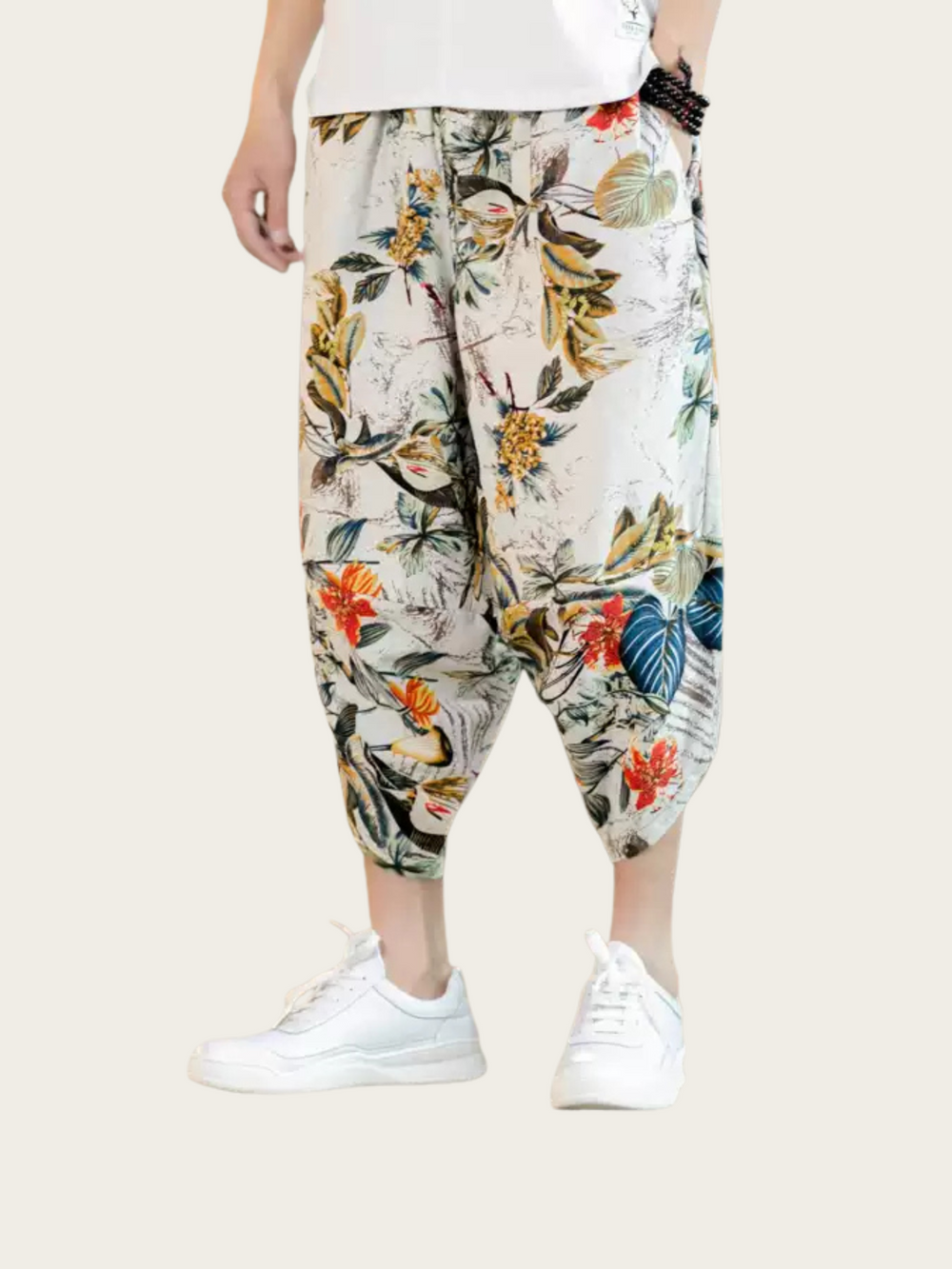 Floral-patterned harem pants worn by a person on a plain background