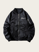 Black bomber jacket with white logo on a beige background