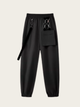 Black pants with suspenders on a light gray background