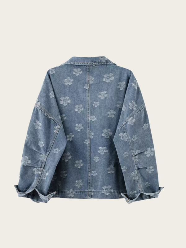 Blue denim jacket with floral pattern on a light gray background