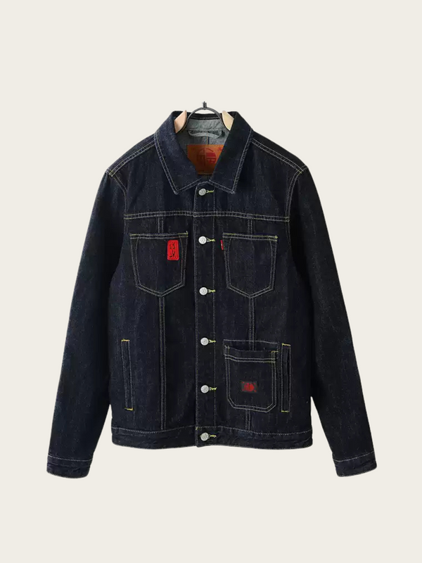Dark denim jacket with red label on a beige background