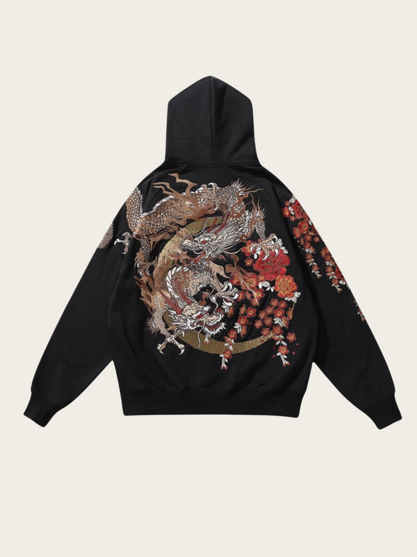 Black hoodie with dragon design on the back against a beige background