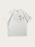 White t-shirt with floral embroidery on a light gray background
