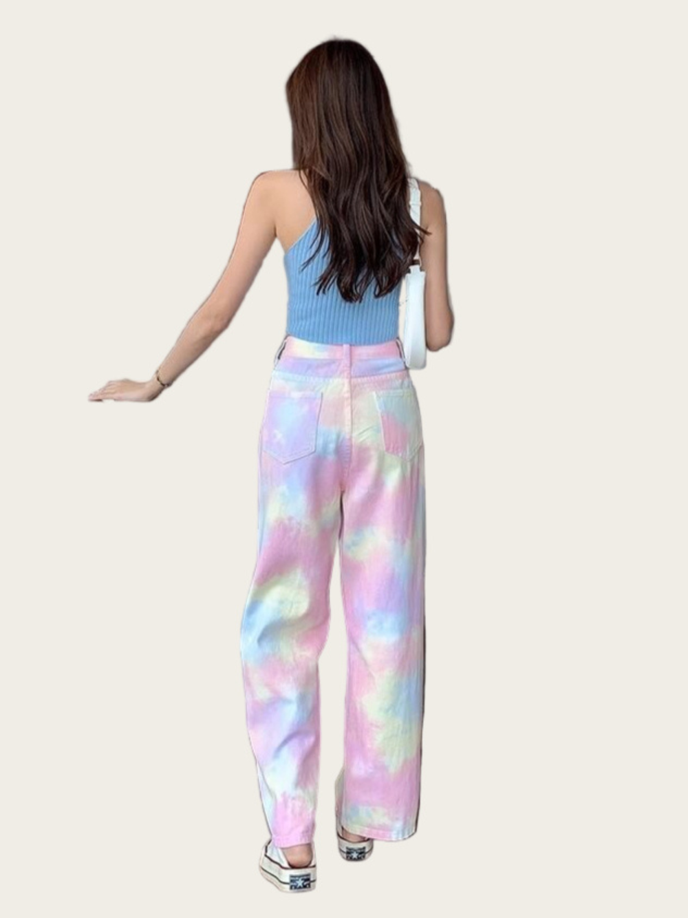Woman wearing colorful tie-dye pants on a plain background