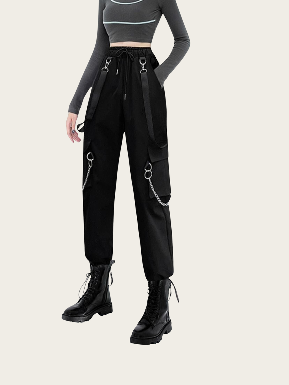 Person wearing black cargo pants with chain details on a white background