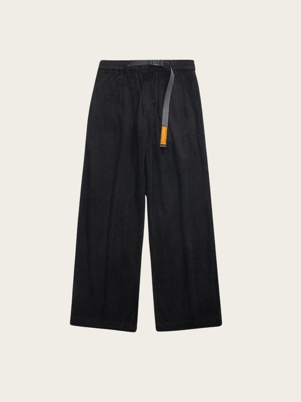 Black pants with a small orange tag on a beige background