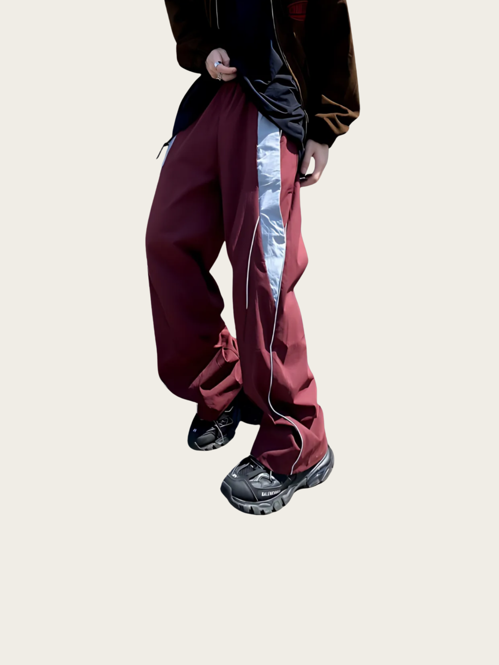 Person wearing maroon pants with a white stripe on a beige background