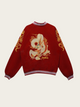 Red sweater with gold dragon design on a beige background