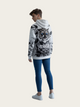 Person wearing a hoodie with a tiger design on a plain background