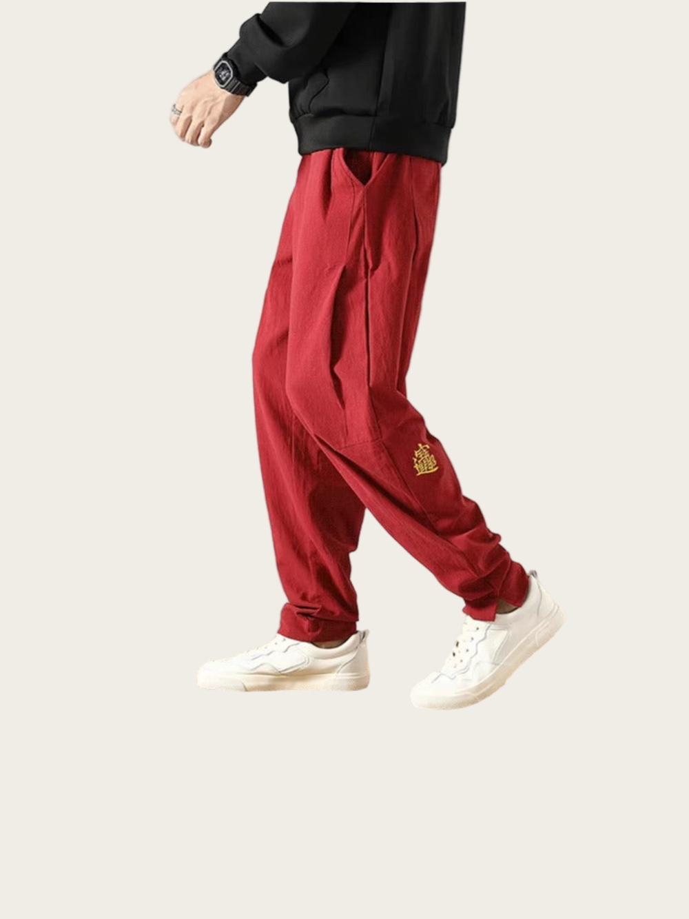 Red pants with a small logo worn by a person on a light gray background