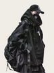 Person wearing a black jacket and backpack on a plain background