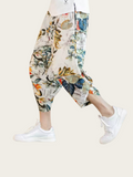 Person wearing floral print harem pants on a plain background