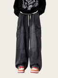 Person wearing a black hoodie with white text and dark gray baggy pants on a light beige background