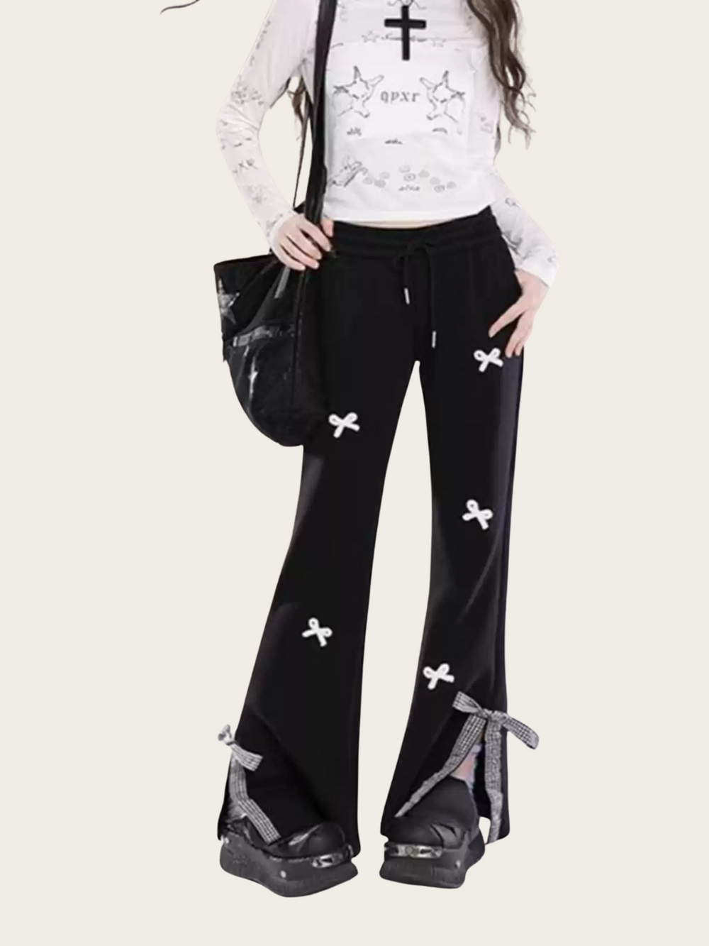 Person wearing black pants with white floral patterns on a white background