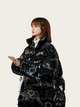 Person wearing a black reflective jacket with patterns on a white background