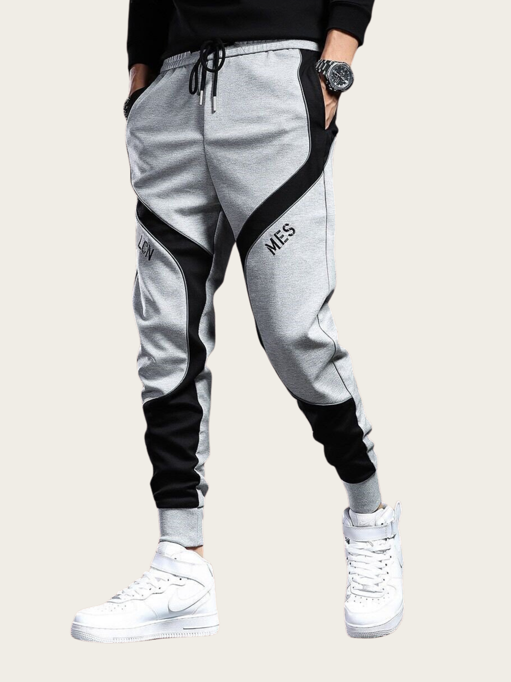Gray jogger pants with black accents worn by a person on a white background