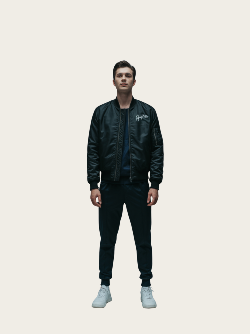 Person wearing a black bomber jacket with branding on a light gray background