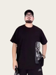 Person wearing a black t-shirt with a graphic design on a plain background