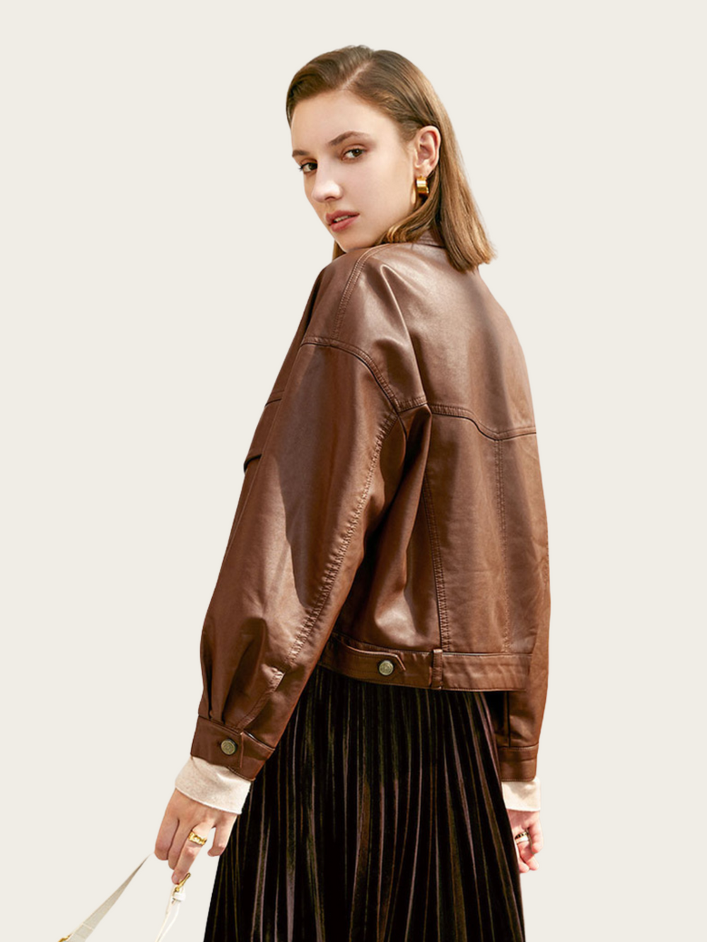 Woman wearing a brown leather jacket on a plain background