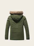 Green parka jacket with fur-lined hood on a beige background