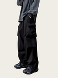 Person wearing black wide-leg pants and a gray long-sleeve shirt on a light gray background