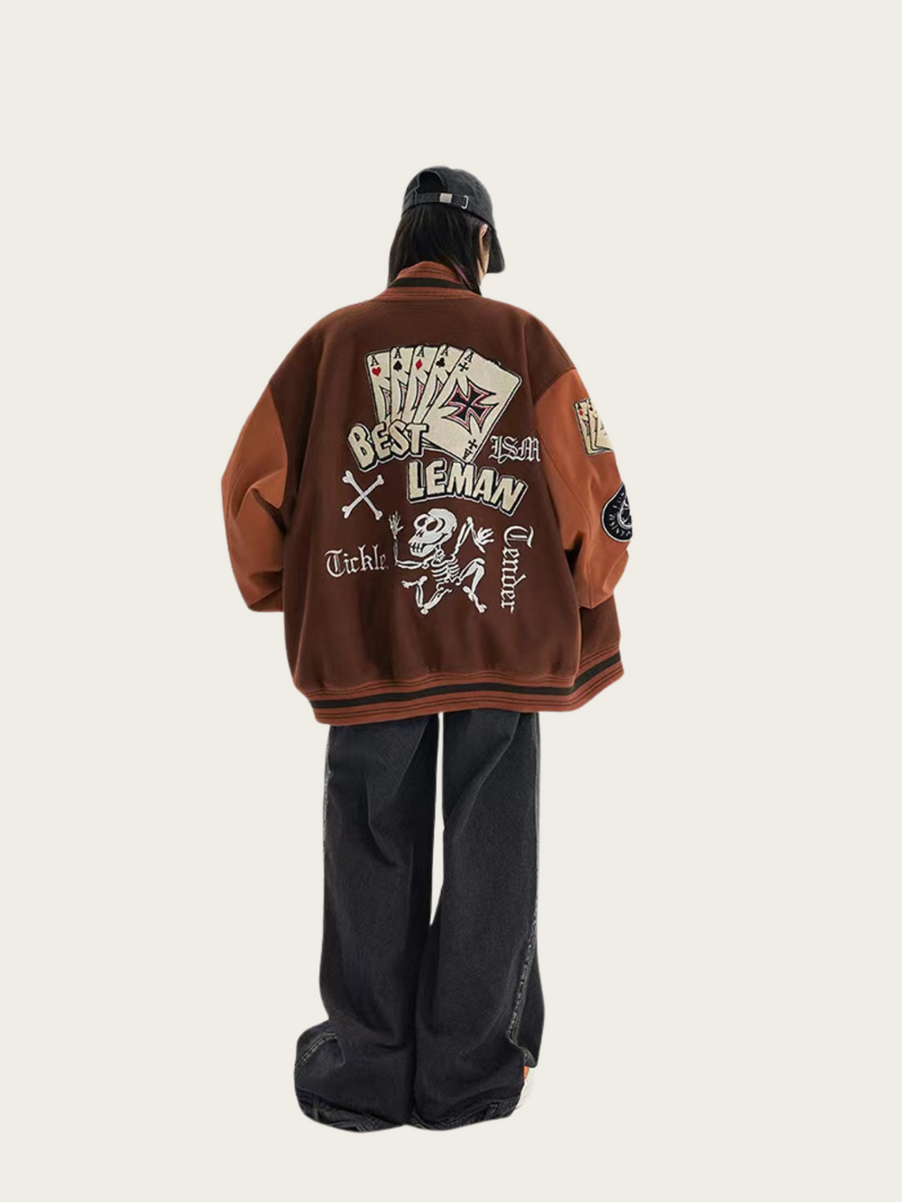 Person wearing a brown jacket with text and graphics on the back, standing against a white background