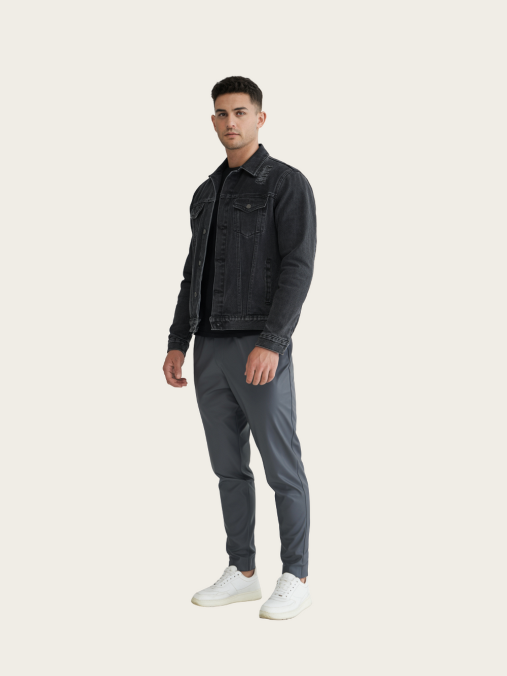 Man wearing a black denim jacket and gray pants on a white background