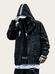 Person wearing a black jacket with reflective stripes on a beige background