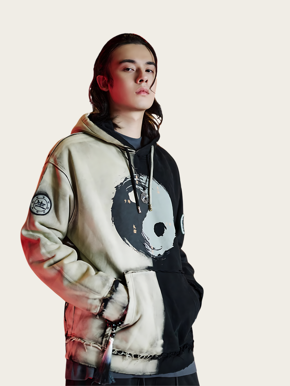 Person wearing a hoodie with a unique design on a light background