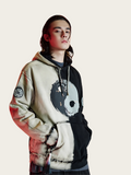 Person wearing a hoodie with a unique design on a light background