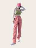 Person wearing a green top, pink pants, and pink cap on a white background