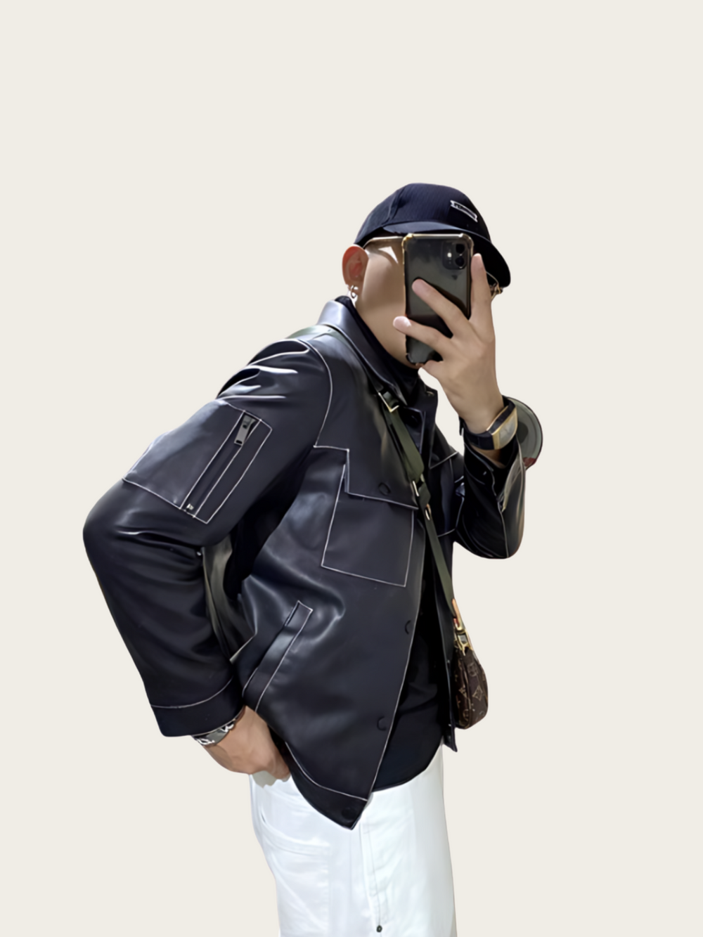Person wearing a black leather jacket and white pants, taking a mirror selfie.