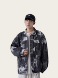 Person wearing a black and gray patterned jacket and cap on a white background