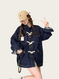 Person wearing a navy blue denim jacket and beige cap on a light background