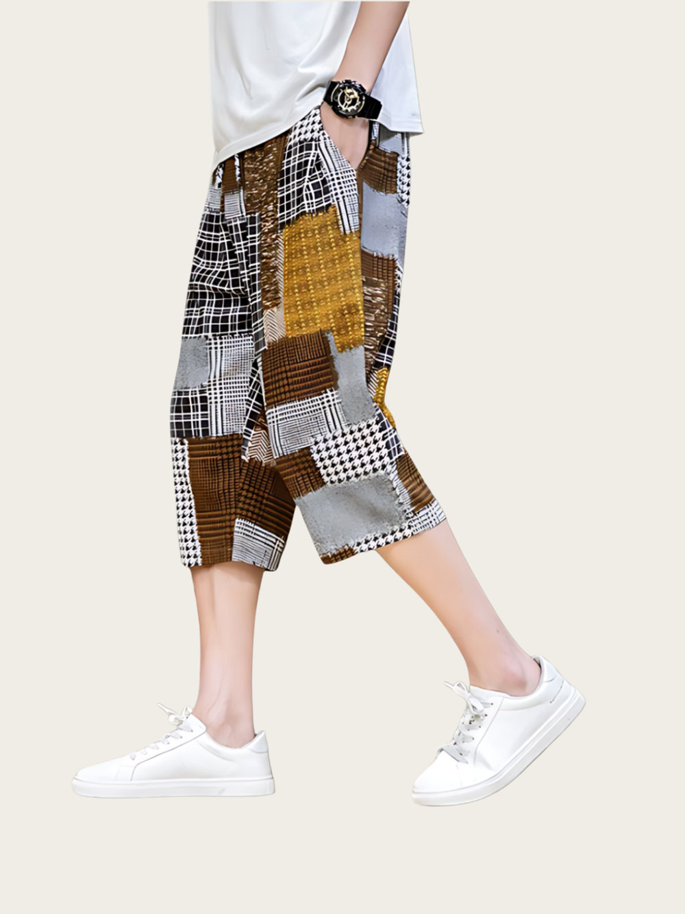 Person wearing a patchwork skirt with white sneakers on a plain background