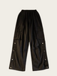 Black cargo pants with button details on a light gray background