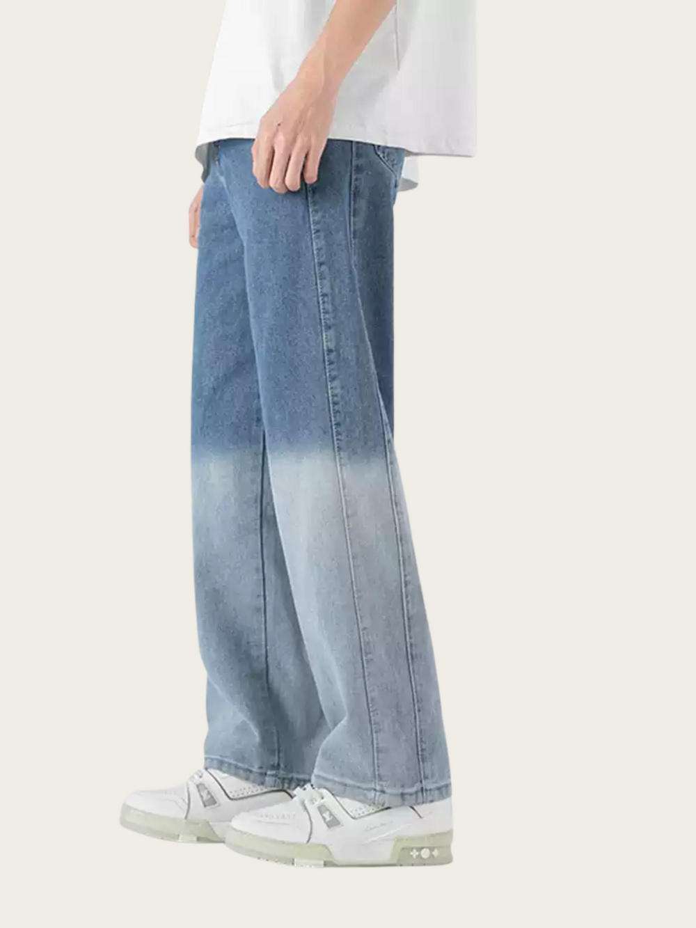 Person wearing light blue gradient jeans with a white shirt on a plain background