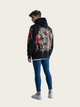 Person wearing a black hoodie with a colorful tiger design on the back, standing against a plain background.