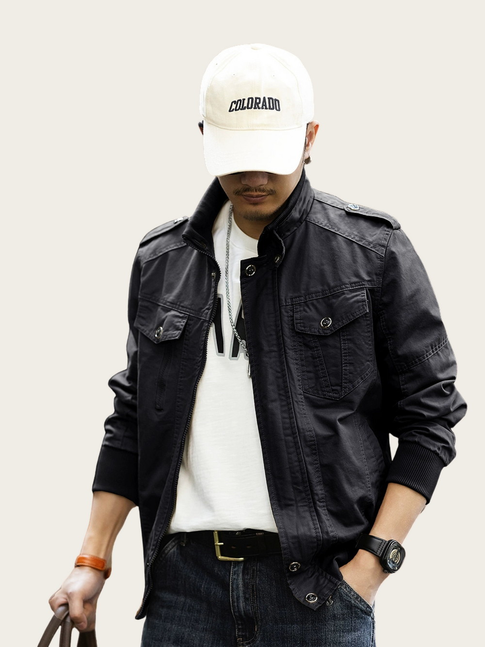 Person wearing a black jacket, white cap, and dark pants on a light background