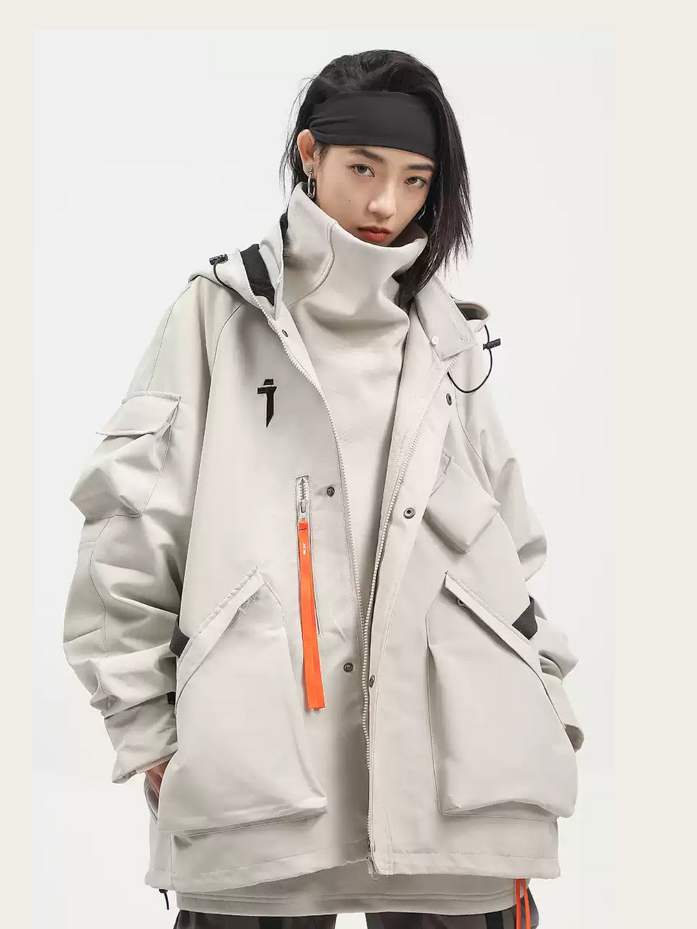 Person wearing a gray and white jacket with a black headband on a white background