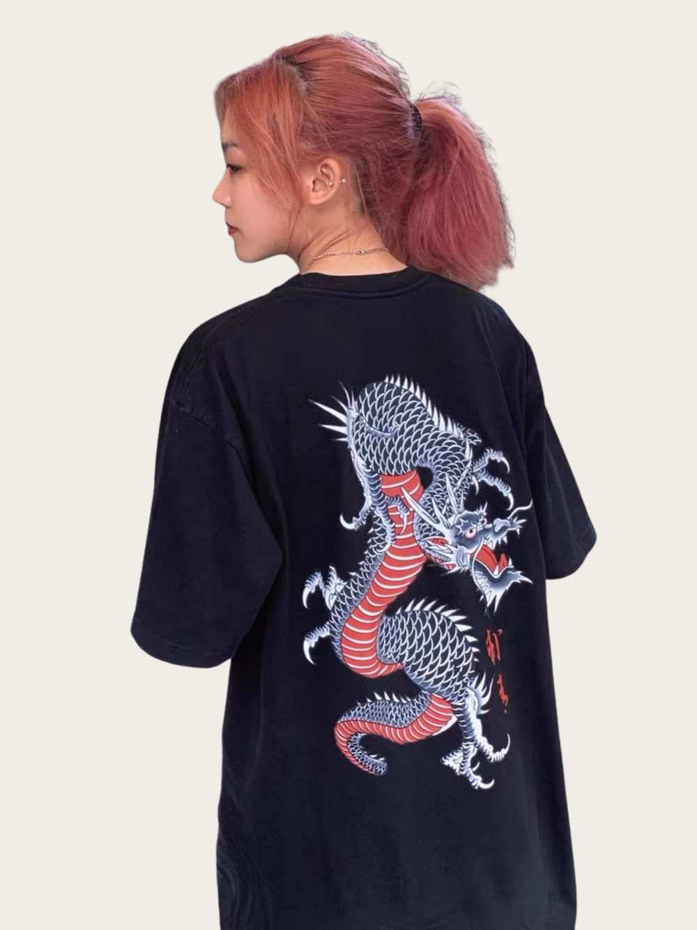 Person wearing a black t-shirt with a dragon design on the back against a plain background