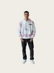 Person wearing a white hoodie with pink floral patterns on a light beige background