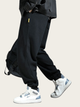 Person wearing black cargo pants and white sneakers on a beige background