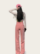 Person wearing pink pants and a cap on a white background